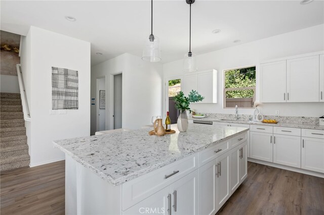 kitchen featuring decorative light fixtures, a center island, dark hardwood / wood-style flooring, and white cabinetry