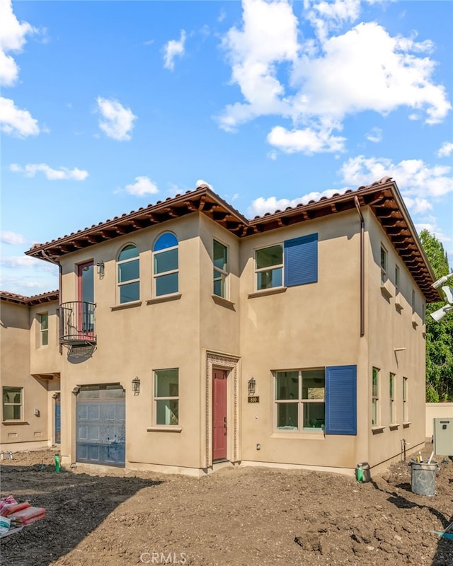 mediterranean / spanish-style house featuring a balcony and a garage