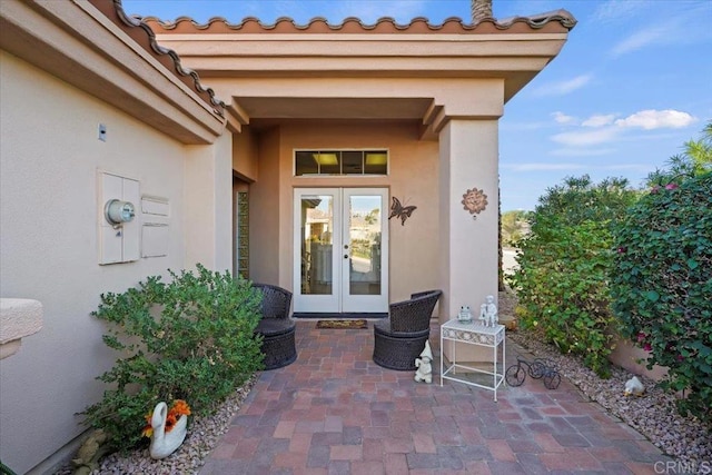 view of exterior entry featuring a patio and french doors