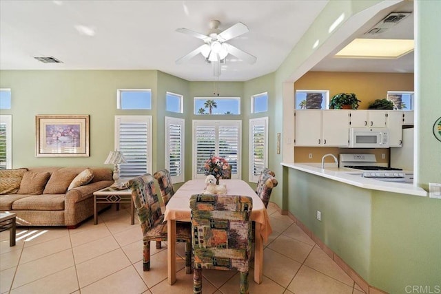 dining space featuring ceiling fan and light tile patterned floors