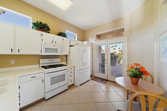 kitchen featuring french doors, white appliances, sink, light tile patterned floors, and white cabinets