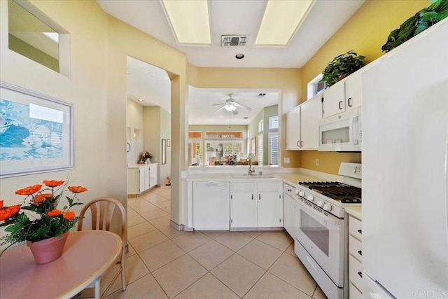 kitchen featuring white appliances, sink, ceiling fan, light tile patterned floors, and white cabinetry