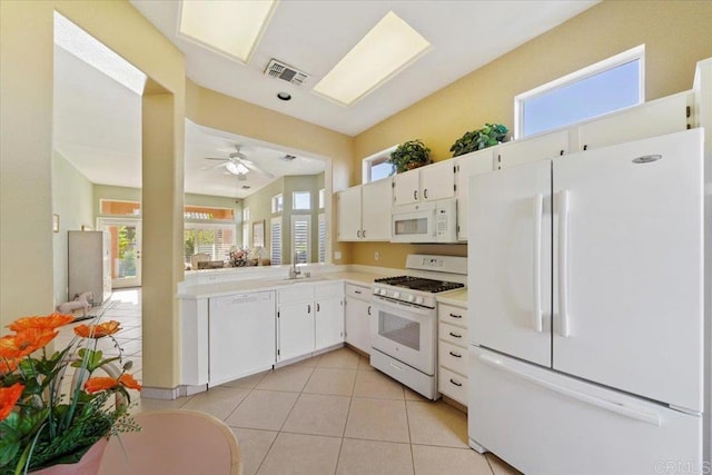 kitchen featuring a wealth of natural light, white cabinets, and white appliances