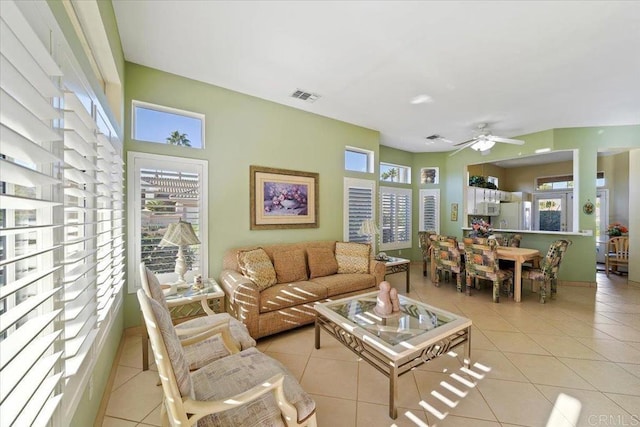 tiled living room with plenty of natural light and ceiling fan