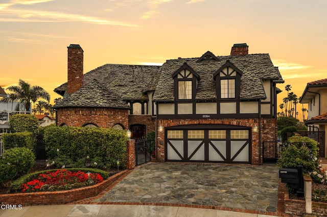 tudor-style house featuring a garage