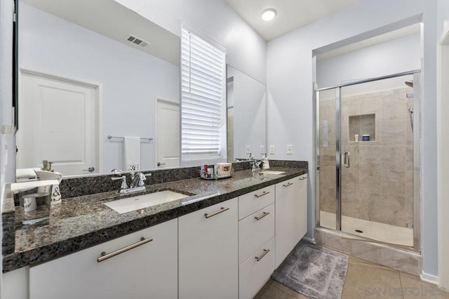 bathroom featuring tile patterned flooring, vanity, and an enclosed shower