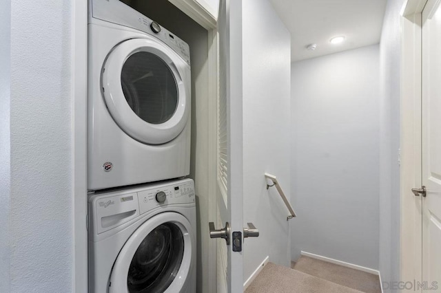 laundry area with light carpet and stacked washer / drying machine