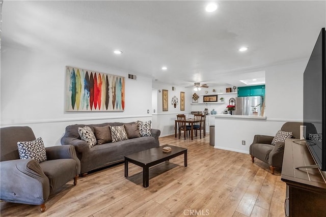 living room featuring ceiling fan and light wood-type flooring