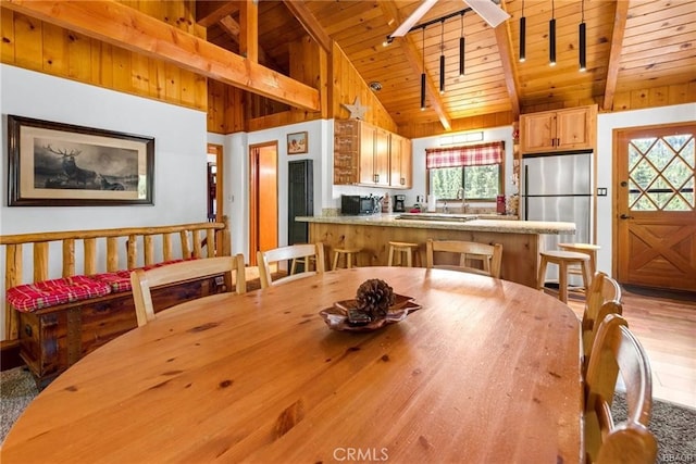 dining room featuring wooden ceiling, light hardwood / wood-style flooring, high vaulted ceiling, and a healthy amount of sunlight