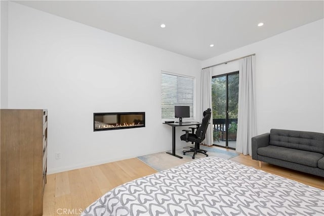 bedroom with access to outside and light hardwood / wood-style flooring