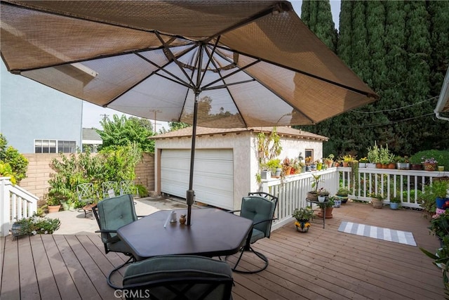 wooden terrace with an outbuilding and a garage