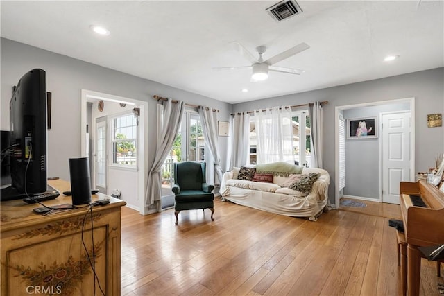 living room featuring light hardwood / wood-style flooring and ceiling fan