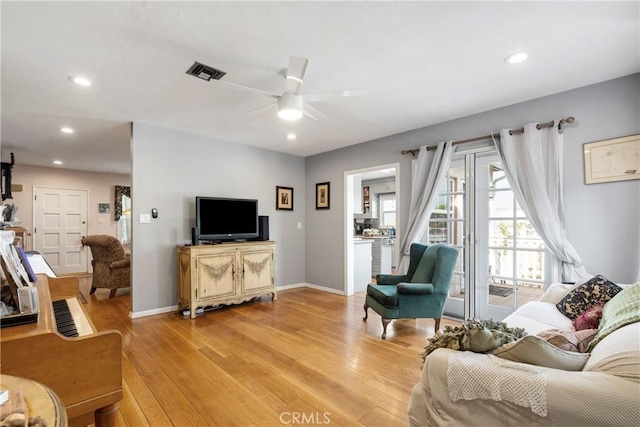 living room with ceiling fan and light hardwood / wood-style floors