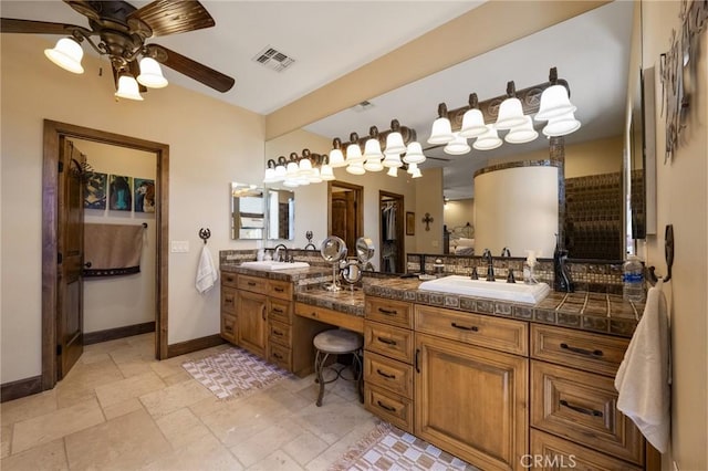 61138 Onaga Trl, Joshua Tree, CA 92252 - bathroom featuring double vanity, a ceiling fan, and stone tile flooring