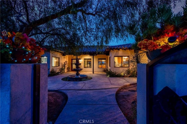 61138 Onaga Trl, Joshua Tree, CA 92252 - doorway to property featuring a tile roof, stucco siding, and a patio area