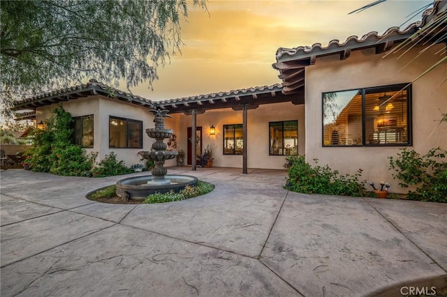 back house at dusk with a patio