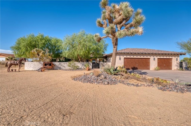 61138 Onaga Trl, Joshua Tree, CA 92252 - view of front of house featuring stucco siding, a garage, concrete driveway, and a tiled roof