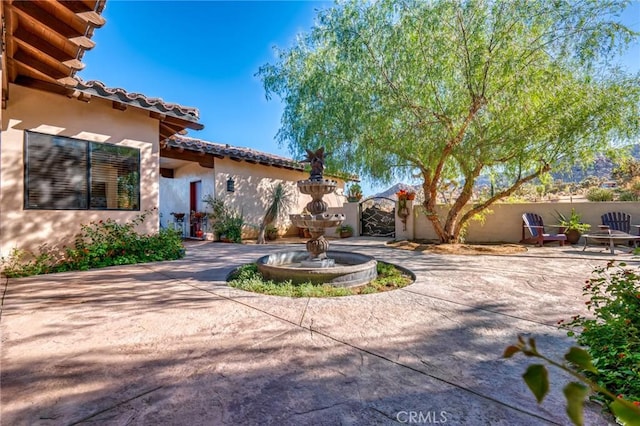 61138 Onaga Trl, Joshua Tree, CA 92252 - view of front facade featuring stucco siding, a patio area, and a tile roof
