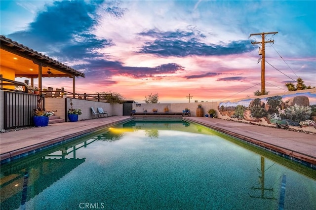 pool at dusk with a patio