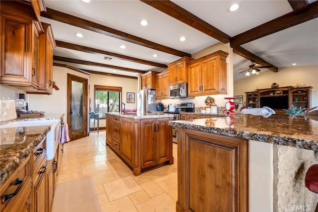 61138 Onaga Trl, Joshua Tree, CA 92252 - kitchen with appliances with stainless steel finishes, beamed ceiling, brown cabinetry, a center island, and recessed lighting
