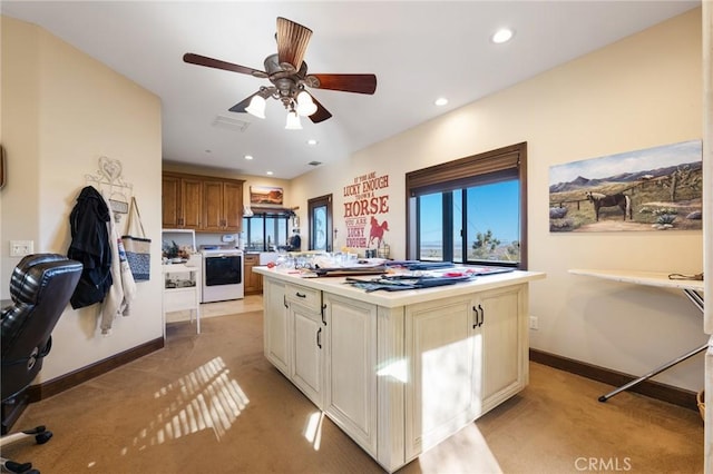 61138 Onaga Trl, Joshua Tree, CA 92252 - kitchen with light colored carpet, light countertops, ceiling fan, a kitchen island, and recessed lighting