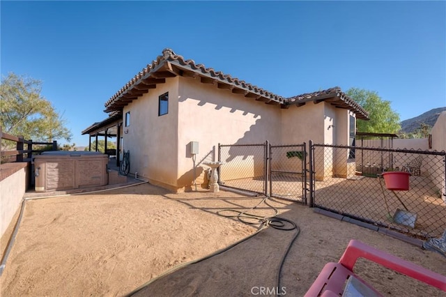 61138 Onaga Trl, Joshua Tree, CA 92252 - rear view of house featuring a gate, stucco siding, and a tile roof