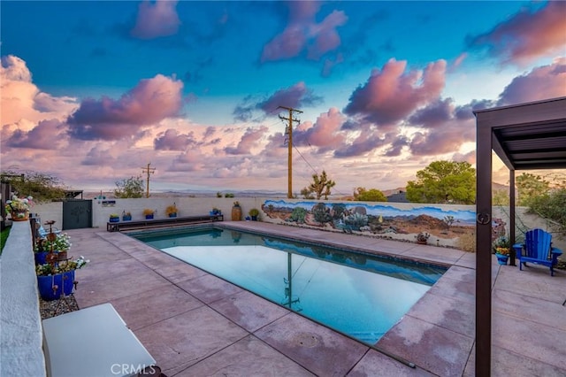 pool at dusk featuring a patio area