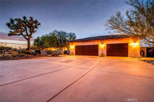 view of garage at dusk