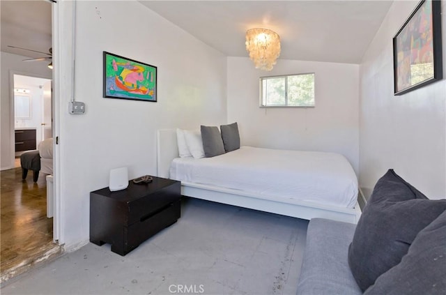 bedroom with connected bathroom, concrete floors, vaulted ceiling, and a notable chandelier