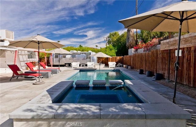 view of pool featuring a patio area and an in ground hot tub