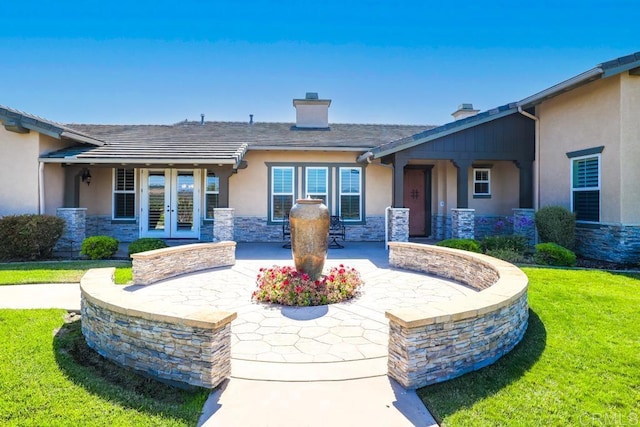 exterior space featuring a lawn and french doors