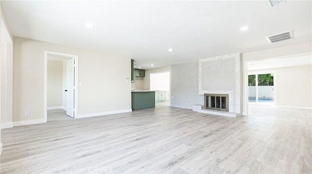 unfurnished living room featuring a fireplace and light wood-type flooring