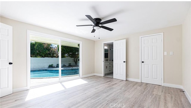 unfurnished bedroom featuring access to exterior, ceiling fan, ensuite bathroom, and light hardwood / wood-style floors