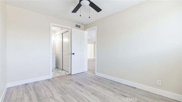 unfurnished bedroom with light wood-type flooring, ceiling fan, and connected bathroom