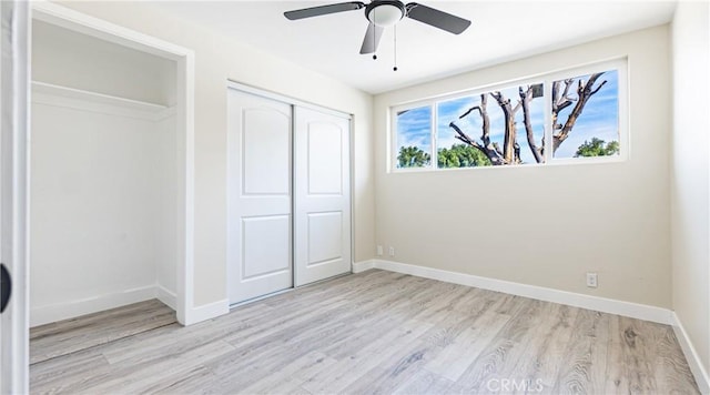 unfurnished bedroom featuring ceiling fan, light hardwood / wood-style floors, and a closet