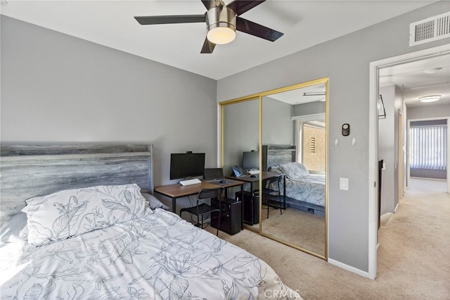 bedroom with ceiling fan, a closet, and light colored carpet