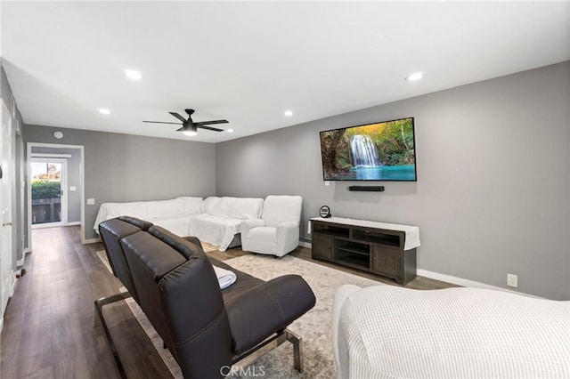 cinema room with hardwood / wood-style floors and ceiling fan