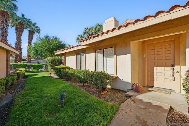 view of exterior entry with a yard