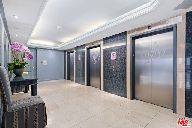 corridor with a raised ceiling, elevator, and ornamental molding