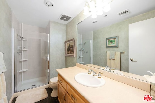 bathroom featuring vanity, toilet, and a shower with door