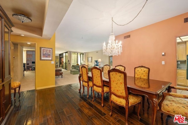 dining room featuring dark wood-type flooring and an inviting chandelier