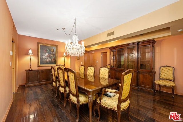 dining room with dark wood-type flooring and a chandelier