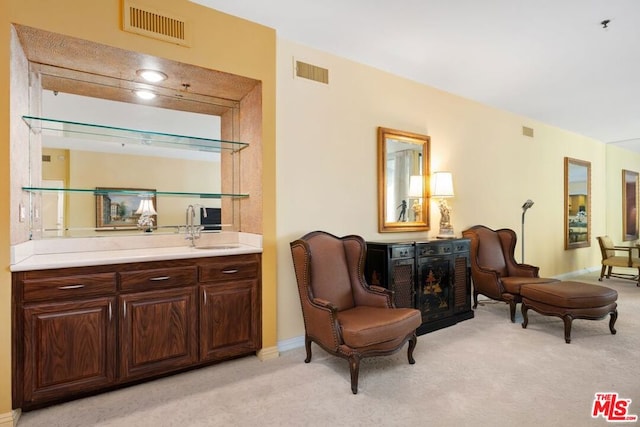 living area with light colored carpet and sink