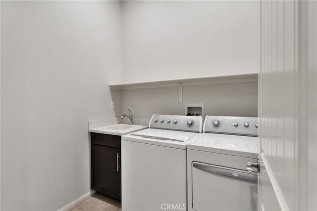 washroom featuring washer and dryer, light tile patterned floors, cabinets, and sink