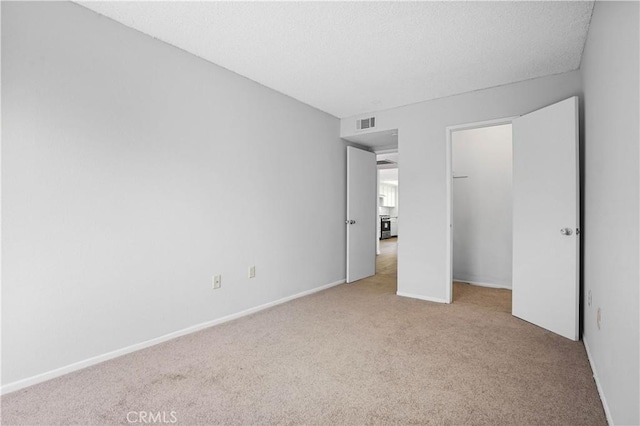 unfurnished bedroom featuring light carpet and a closet