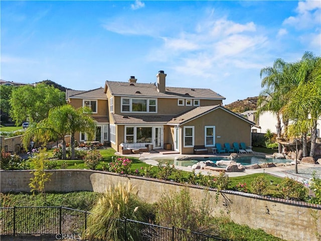 back of property with a fenced in pool, an outdoor hangout area, and a patio