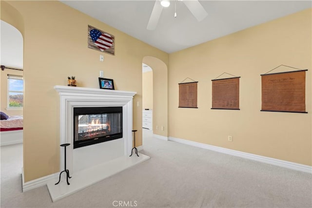 unfurnished living room featuring carpet and ceiling fan