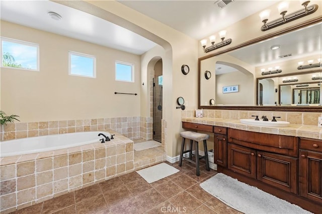 bathroom with shower with separate bathtub, vanity, tile patterned floors, and a wealth of natural light