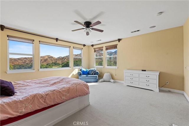 carpeted bedroom featuring a mountain view and ceiling fan