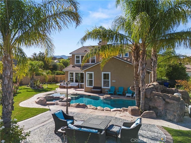 exterior space with outdoor lounge area, an in ground hot tub, a patio, and a lawn